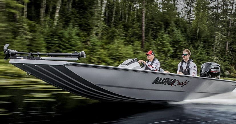 Fishing boat cruising a forest-lined lake for angling trips