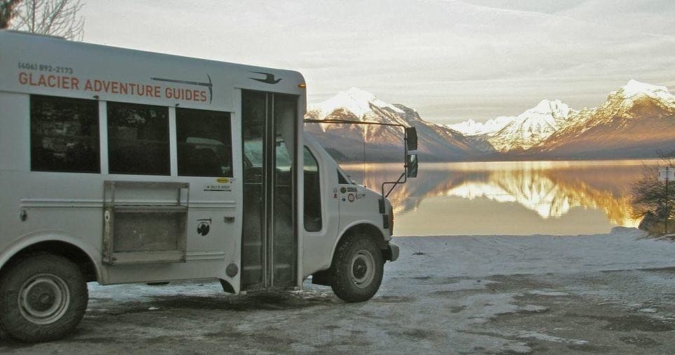 Glacier Adventure Guides shuttle at lakeshore with mountain vista