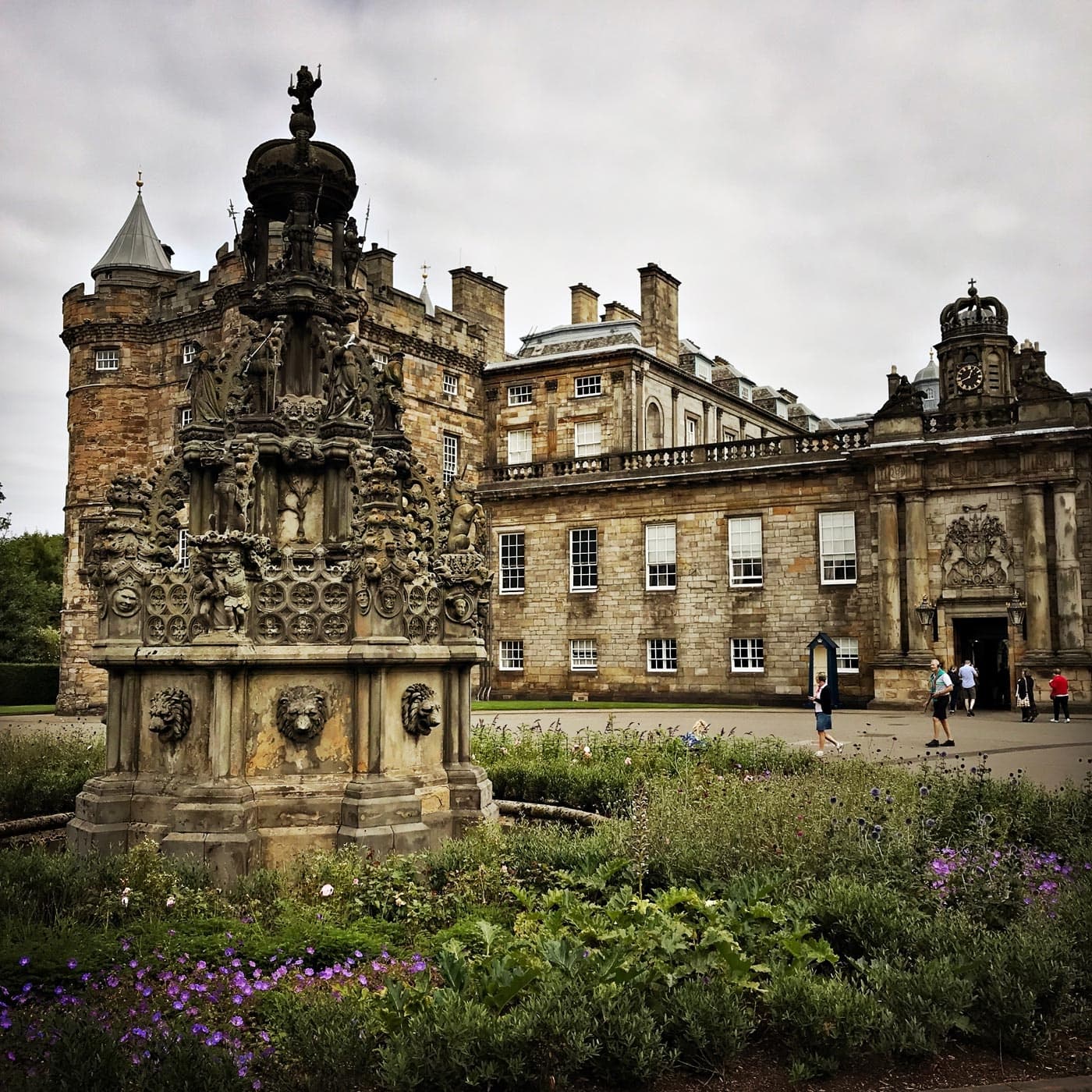 Ornate stone fountain and historic palace facade in formal gardens