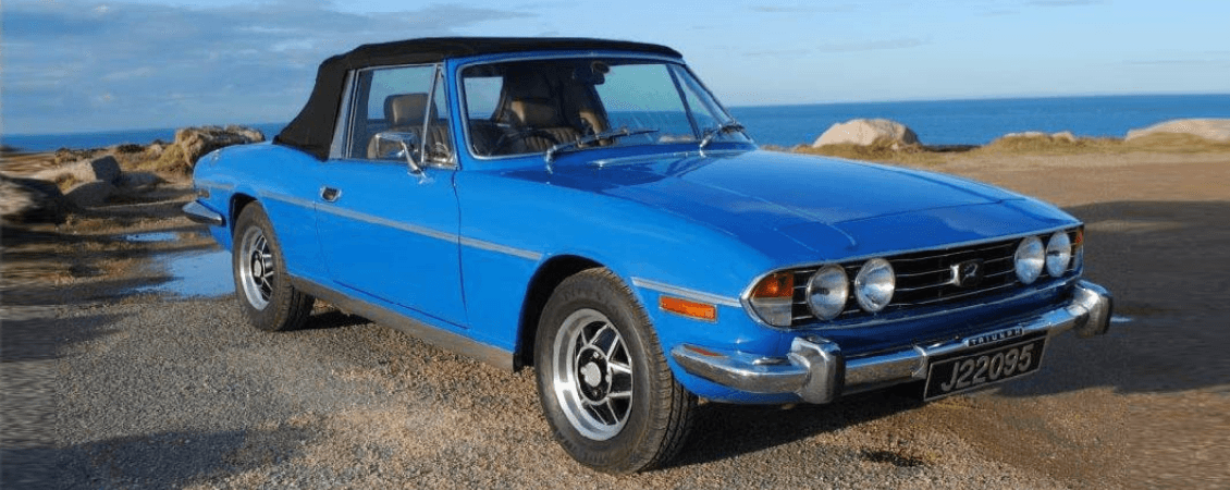 Blue Triumph convertible on coastal road for Jersey scenic drive
