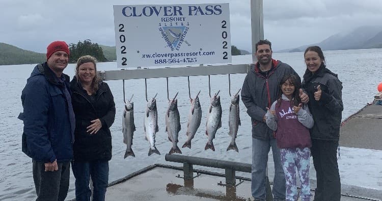 Fishing charter anglers posing with salmon on Alaska dock