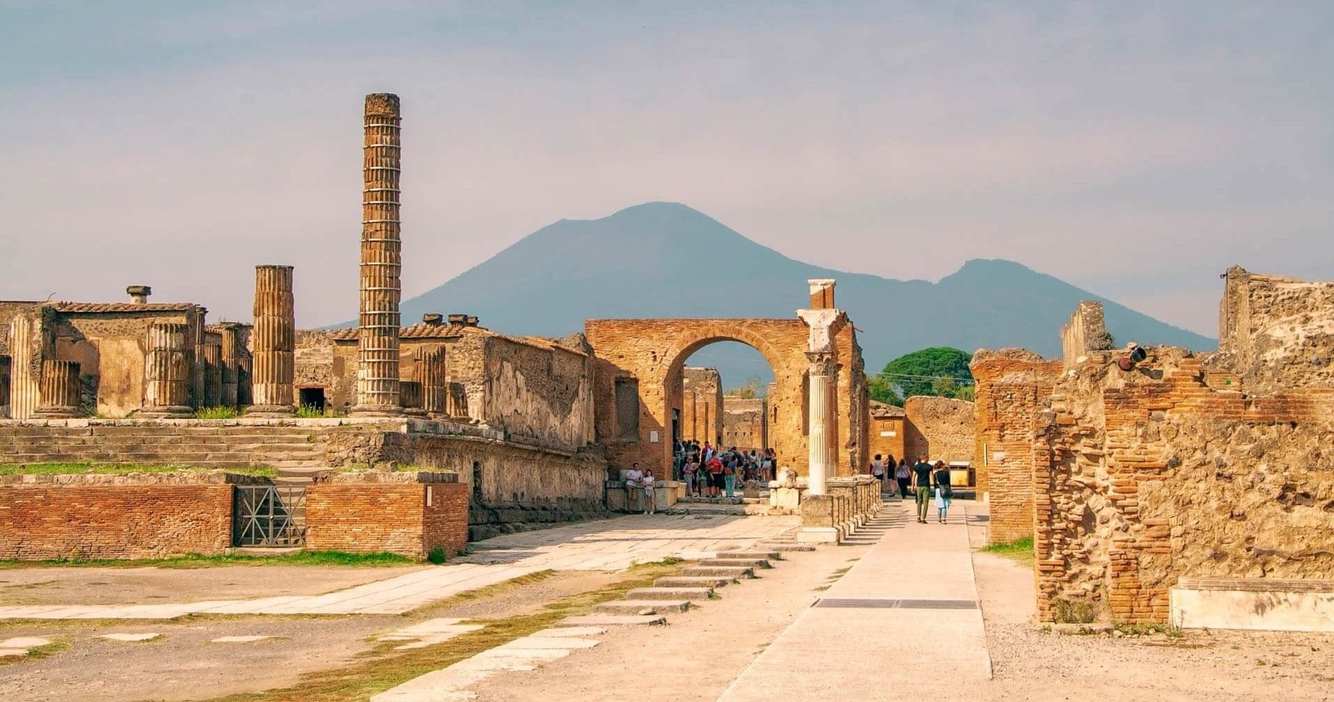 Roman Pompeii street ruins leading toward Mount Vesuvius, open-air tour