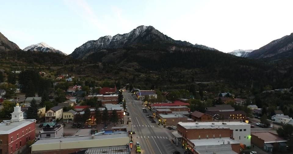 Small mountain town aerial with main street and surrounding peaks