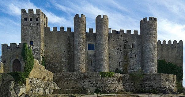 Large coastal castle perched on rocky cliffs overlooking sea
