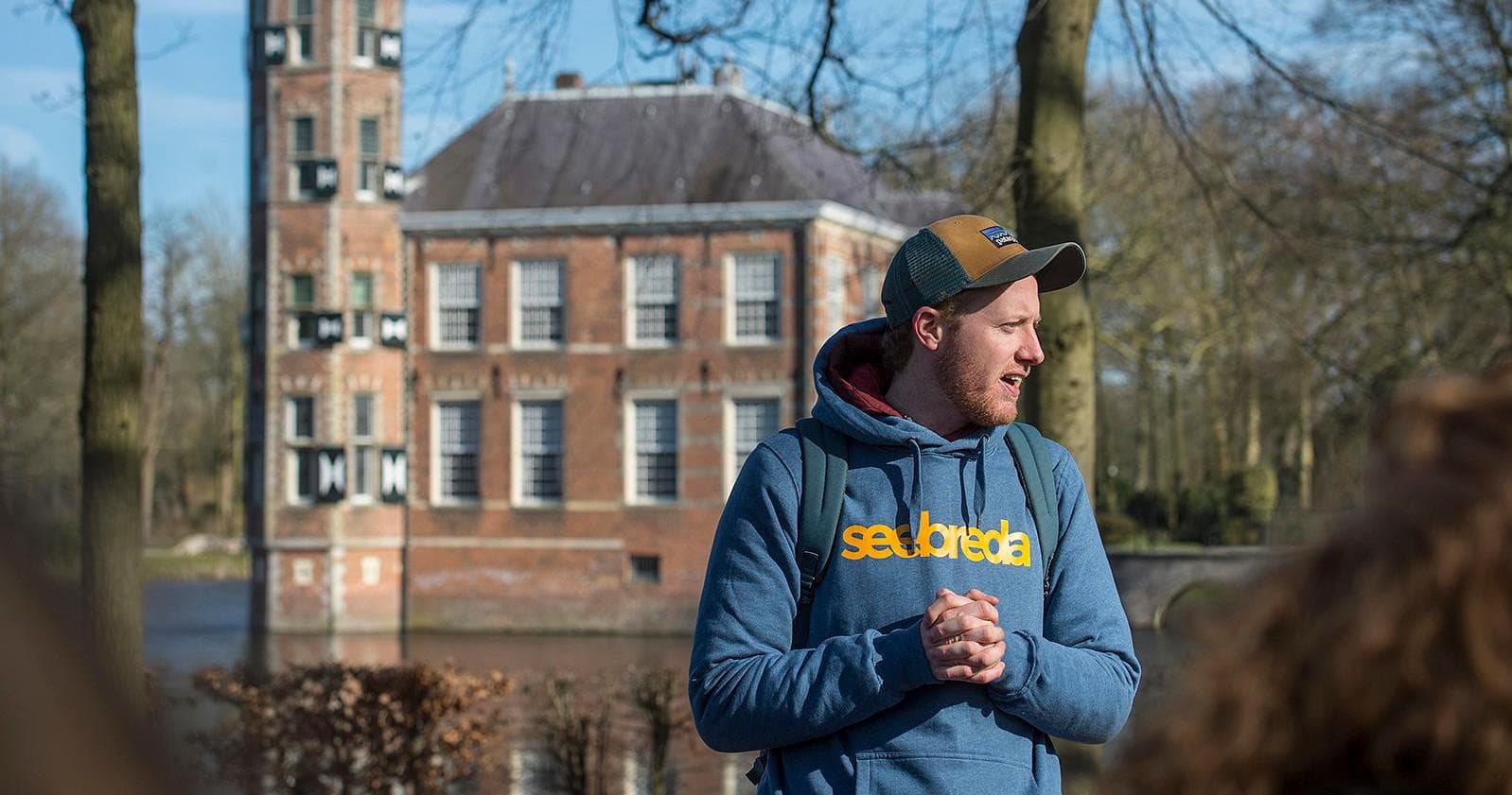 Guide speaking near historic canal house in Breda outdoors
