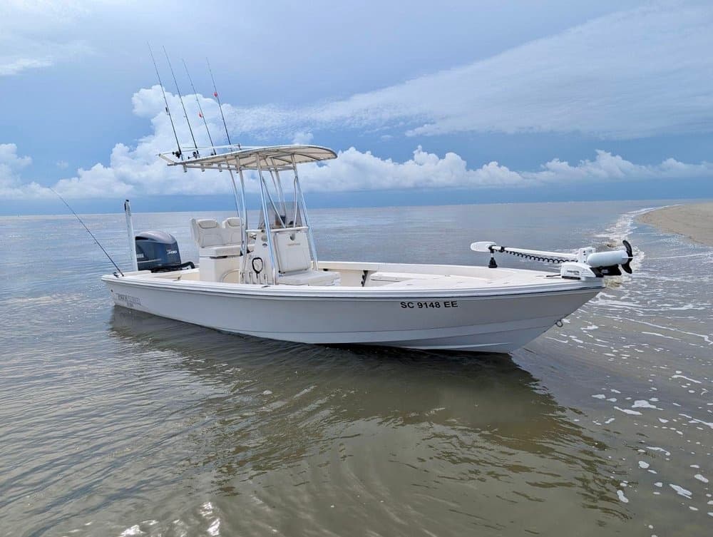 Center console boat grounded in shallow coastal inlet