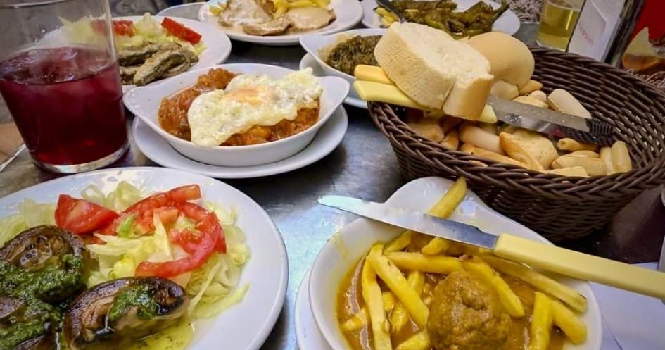Spanish tapas and drinks spread on table at cozy indoor restaurant