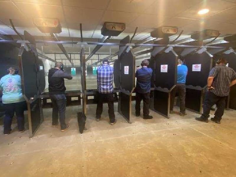Group of shooters at indoor firing lanes practicing handgun skills