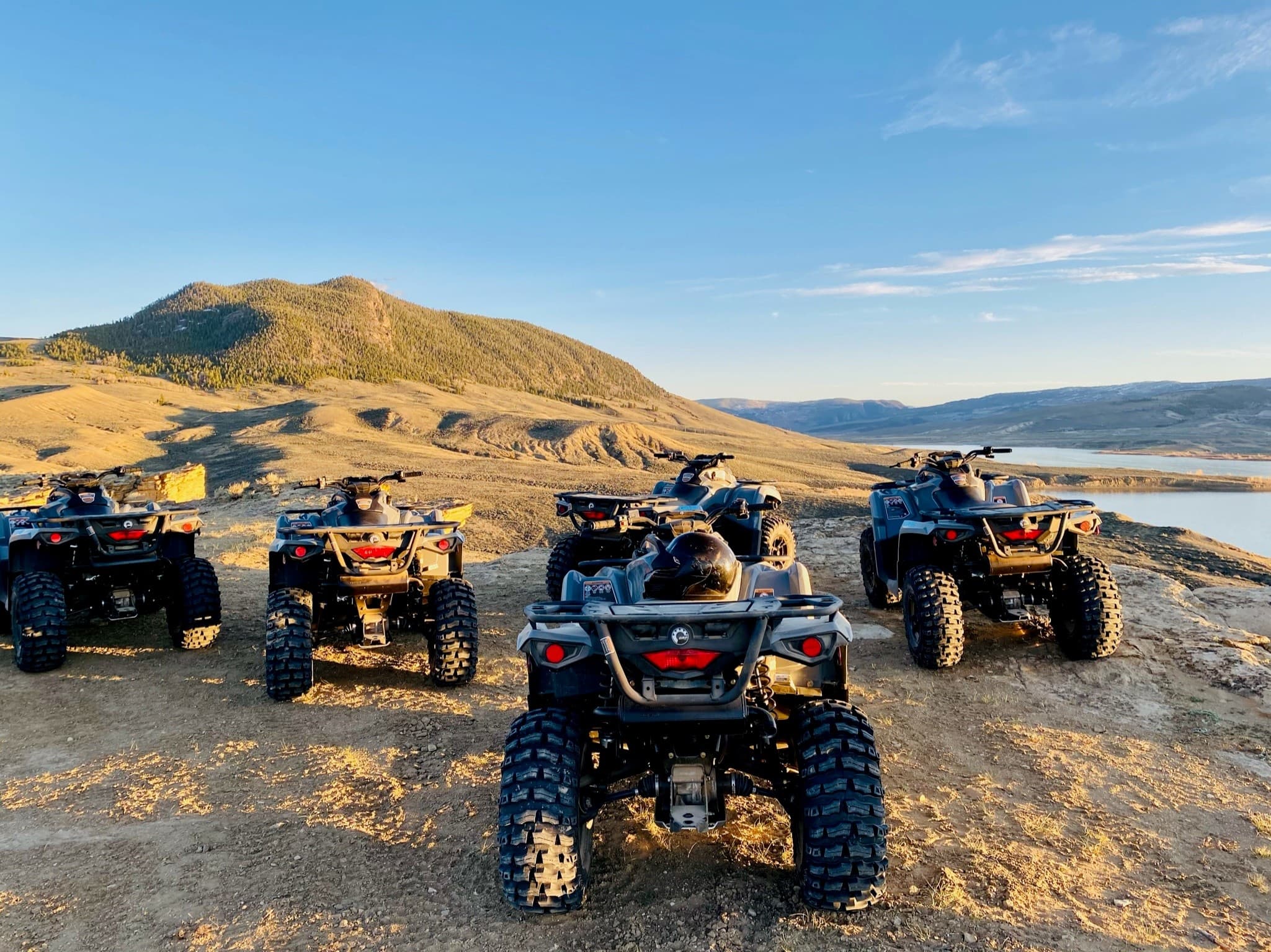 Group of ATVs lined on ridge overlooking expansive valley