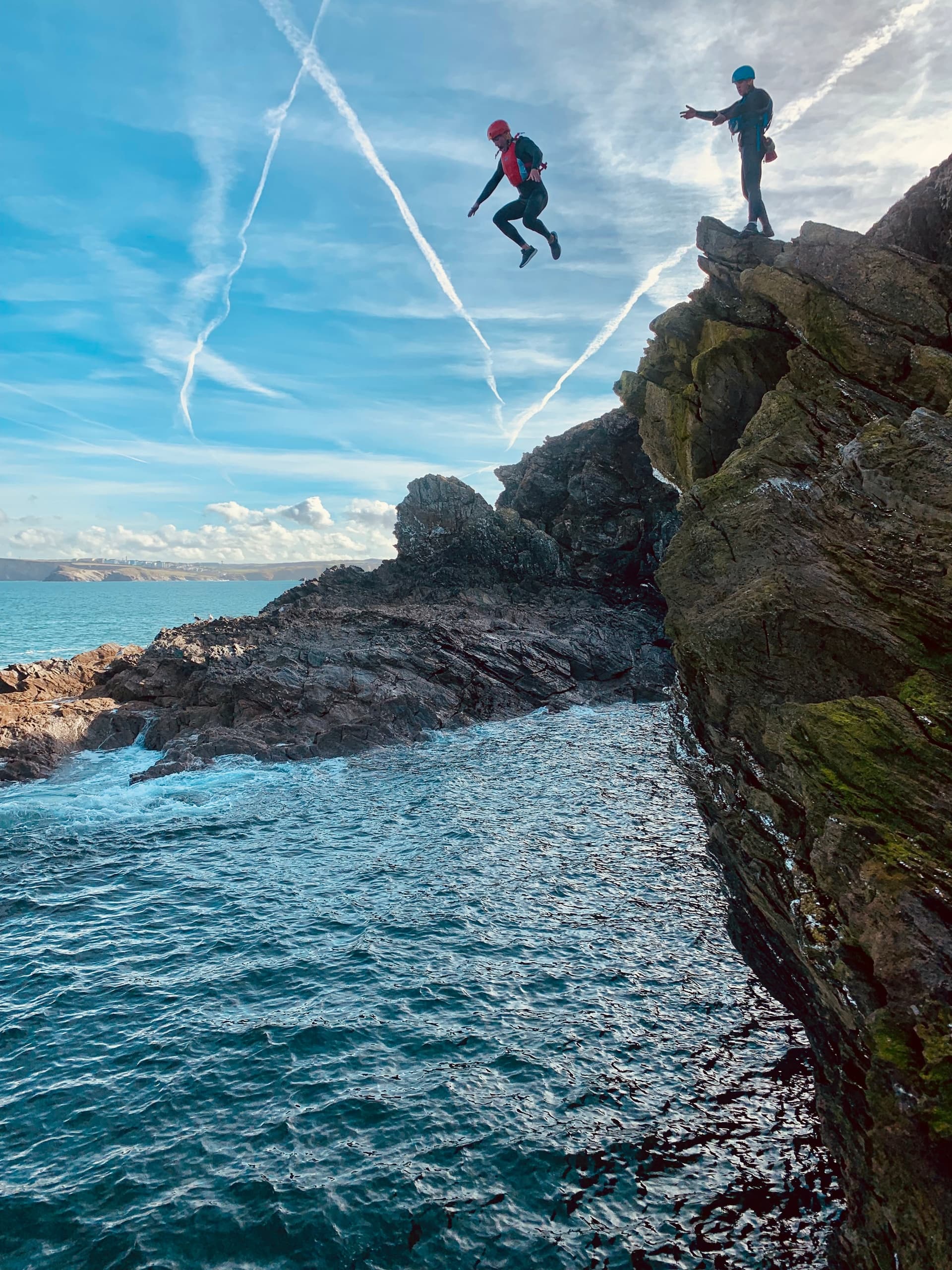Coasteering cliff jump into coastal Atlantic waters near Newquay