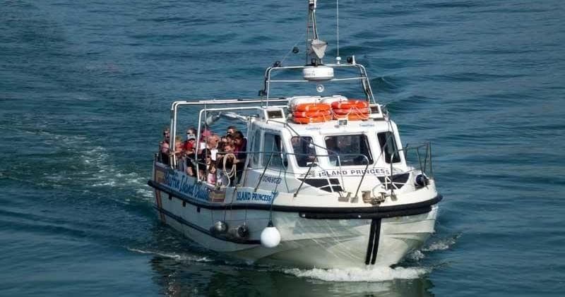 Passenger charter boat underway on open sea, coastal tour trip