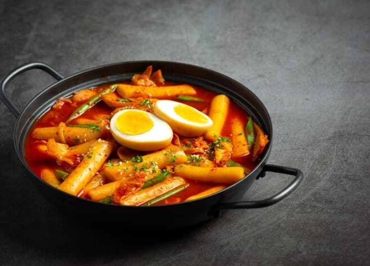 Steaming spicy tteokbokki with egg in Korean restaurant bowl