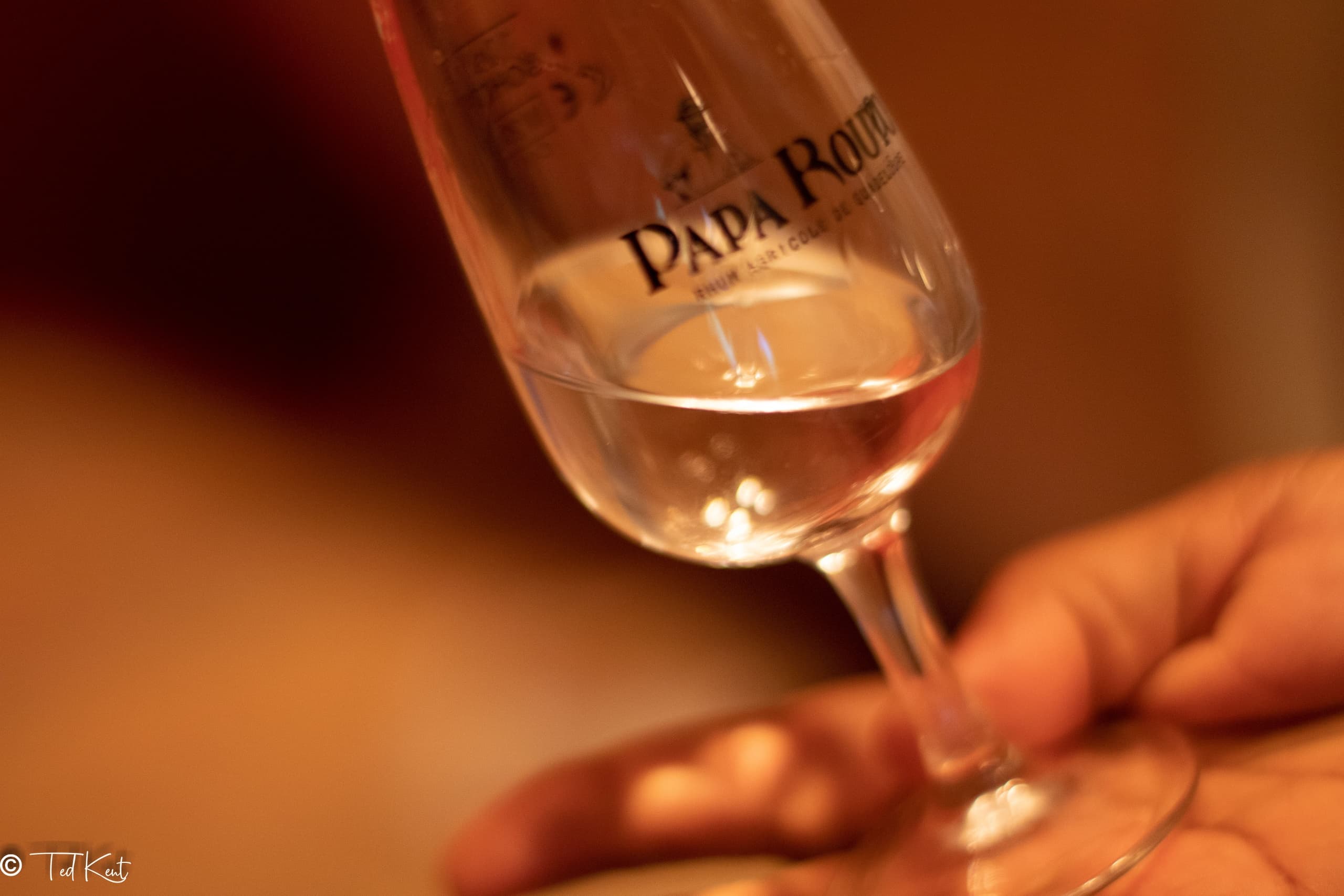 Close-up rum tasting glass with warm bokeh at distillery