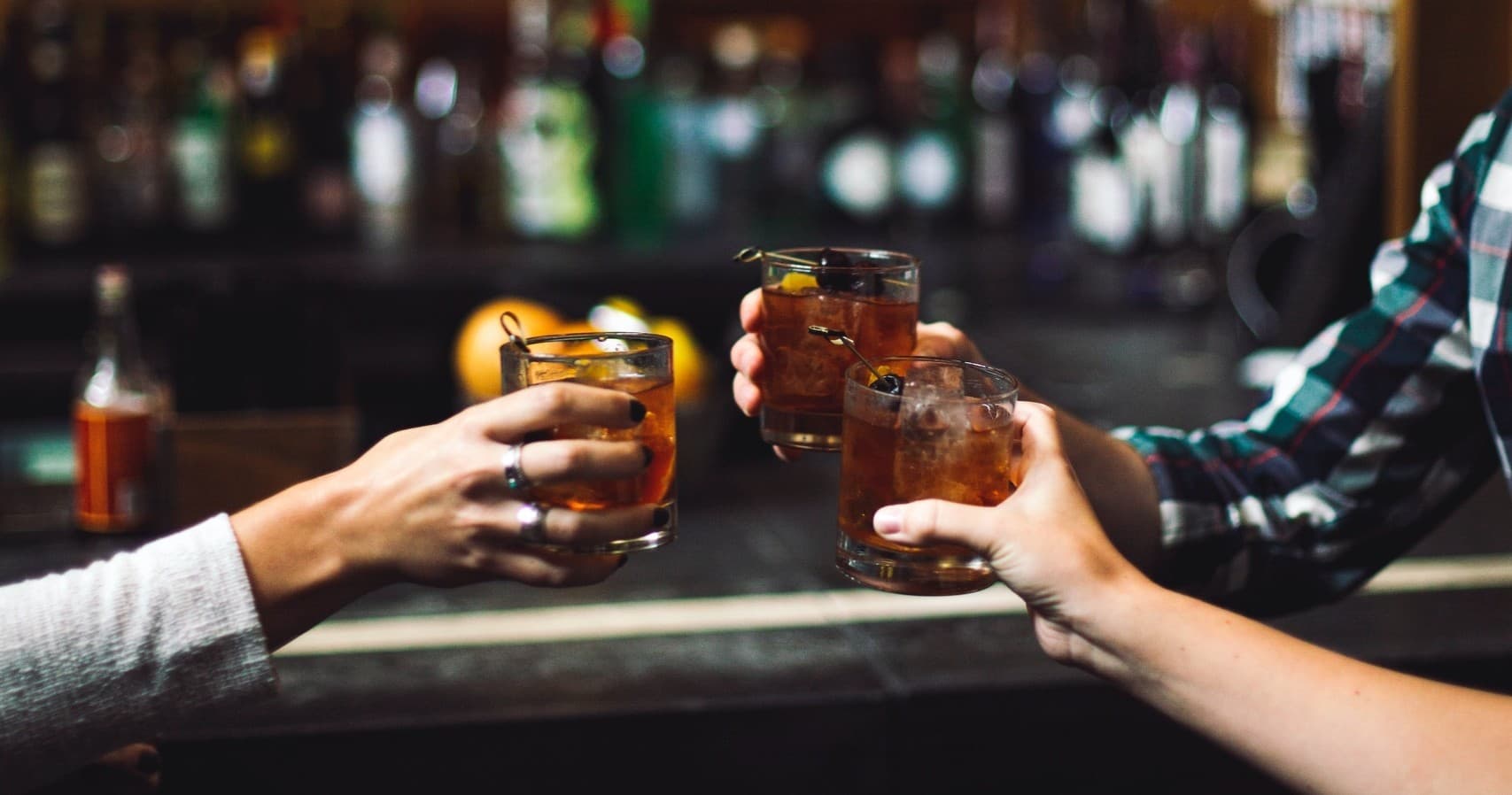 Friends clinking cocktails at bar during Las Vegas nightlife outing