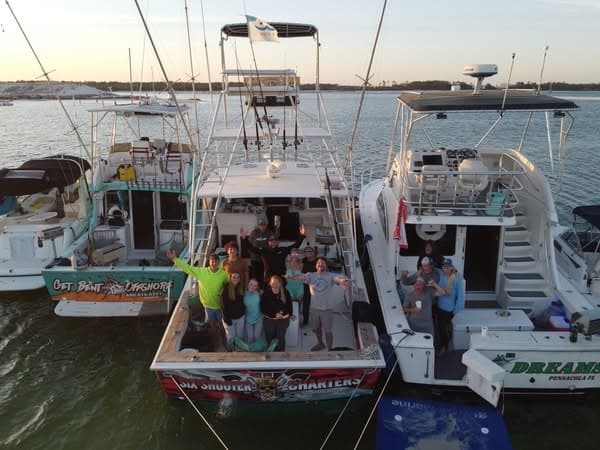 Charter fishing boats tied at marina with crew on deck