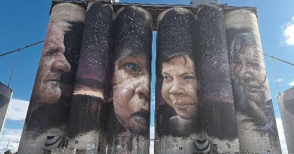 Silo art mural of indigenous faces on rural grain silos