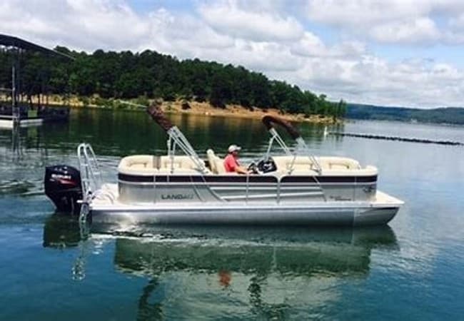 Small pontoon boat anchored near wooded Honey Creek shore