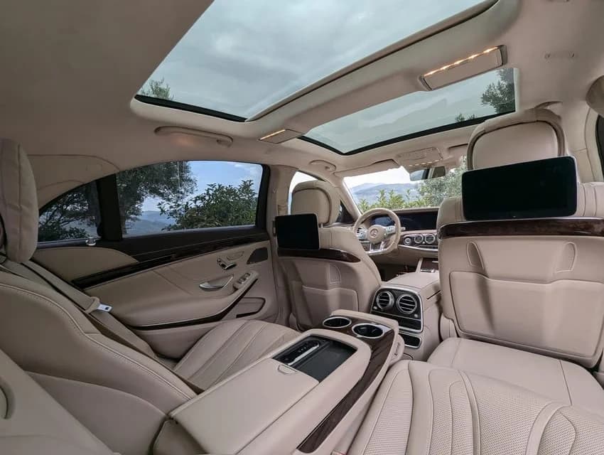 Luxury car interior with panoramic sunroof, beige leather seating