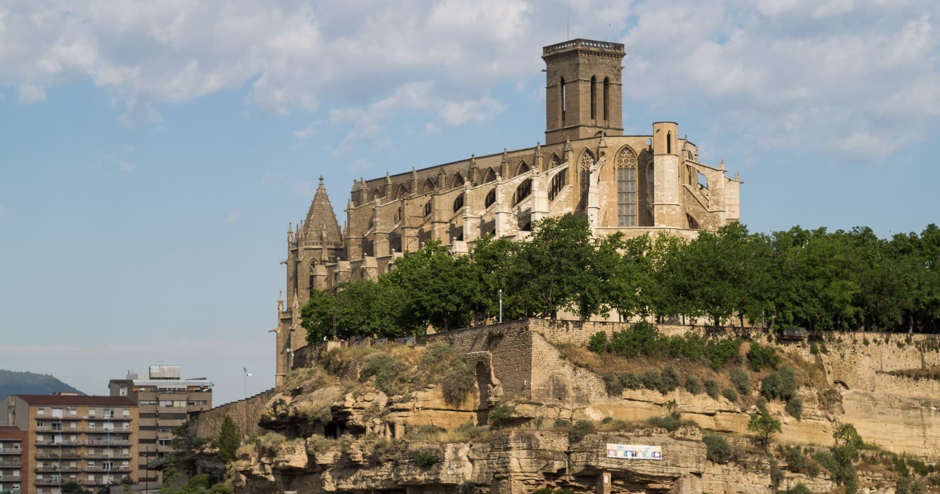 Hilltop cathedral on rocky cliff overlooking town, scenic viewpoint