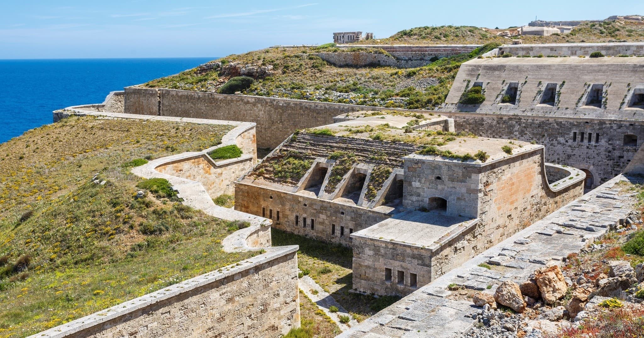 Panoramic coastal fortress ruins on Menorca cliffs overlooking sea