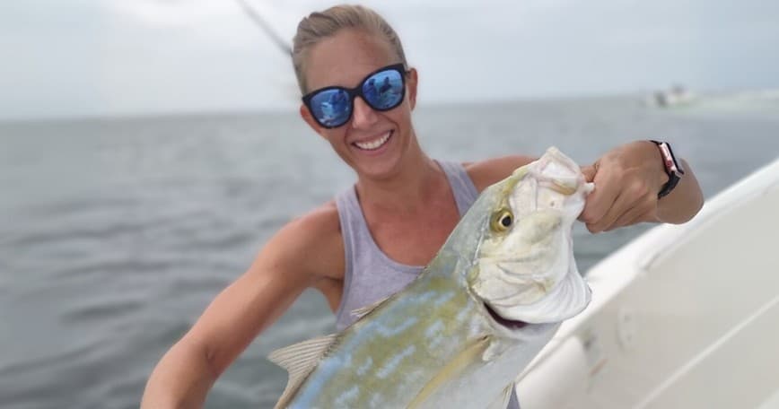 Angler holding large fish aboard offshore sportfishing boat