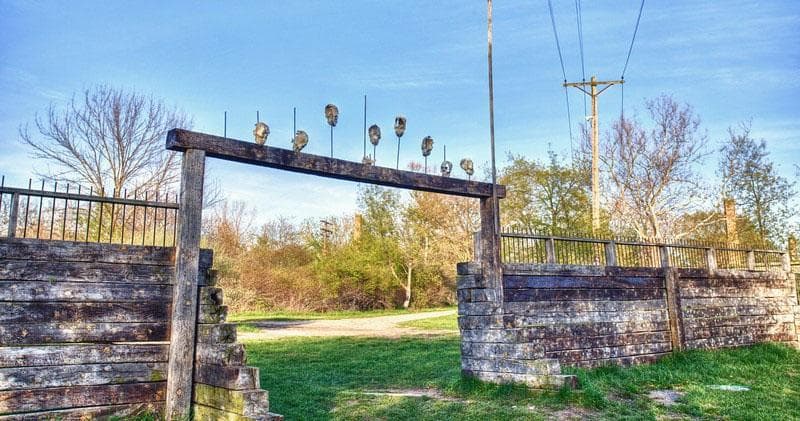 Entrance gate and wooden barricades at outdoor paintball course