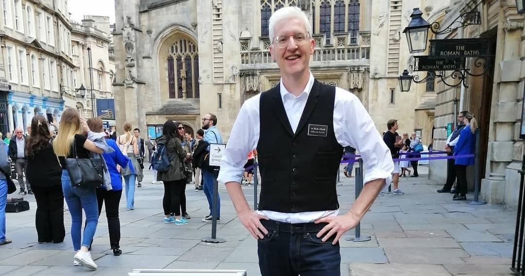 Tour guide leading historical walking tour in Bath city streets
