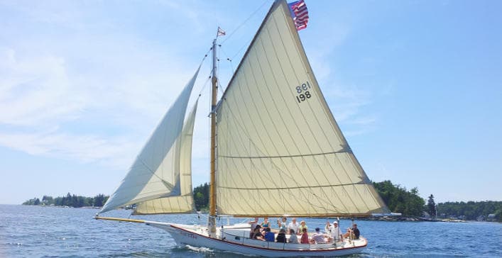 Schooner sailboat cruising coastal waters under full sail