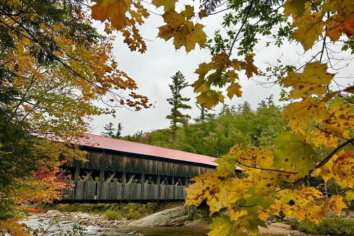 Covered wooden bridge framed by colorful autumn foliage
