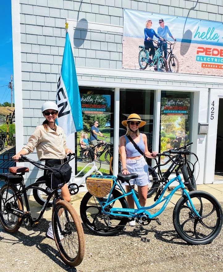 Couple renting electric bikes outside coastal Pedego shop