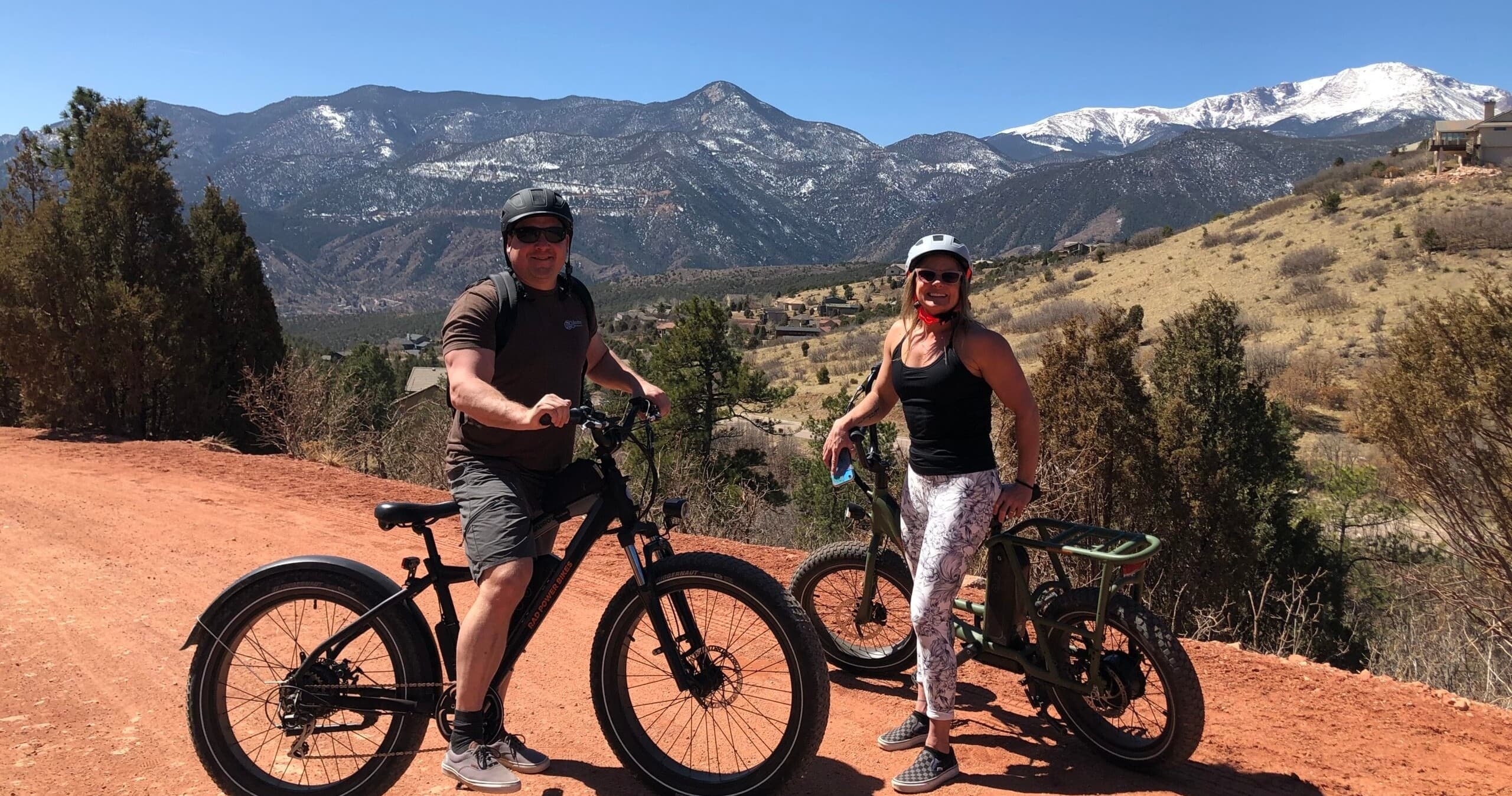 Couple on e-bikes overlooking redrock trails and mountains