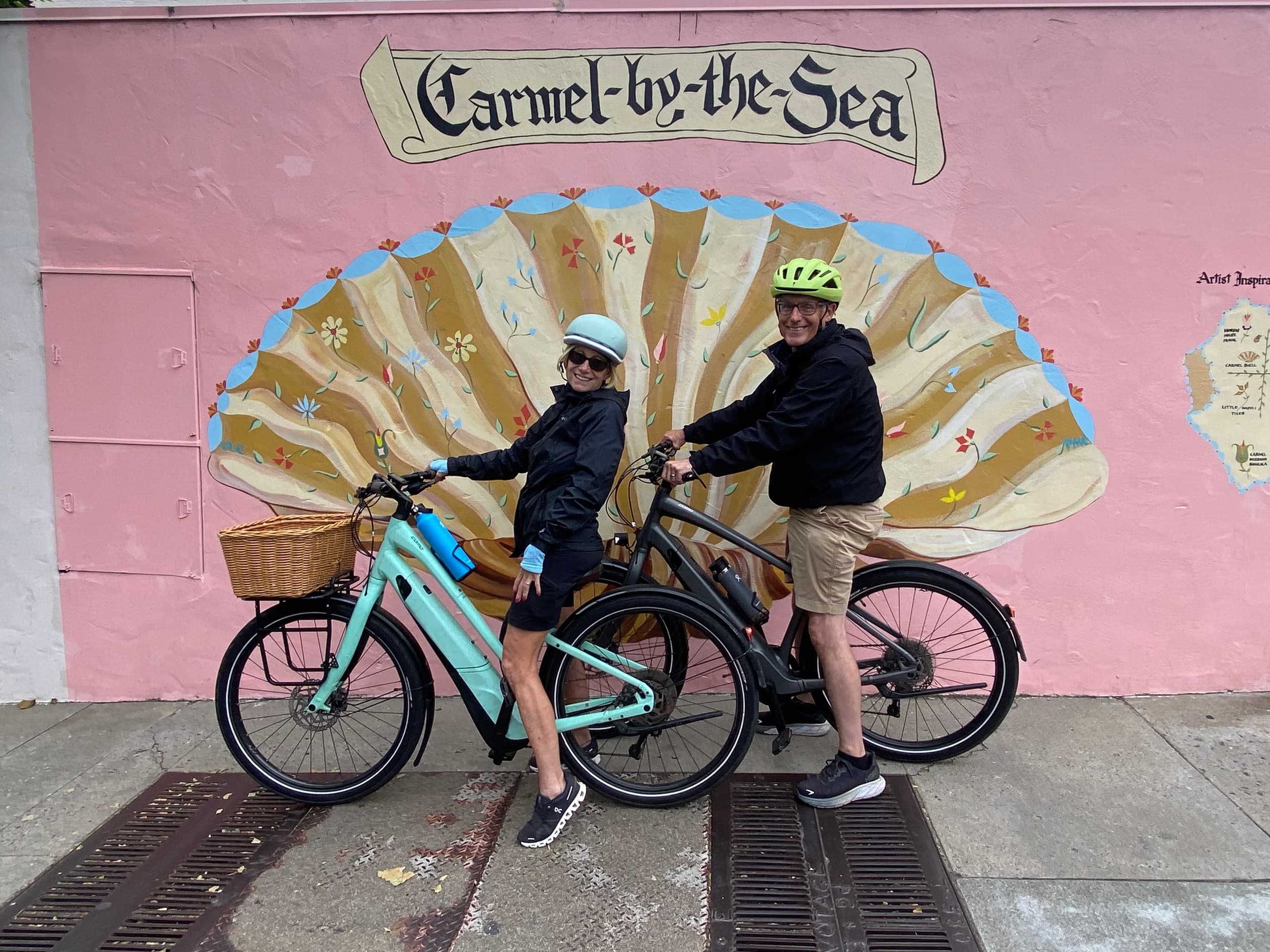 Couple on bikes in front of Carmel-by-the-Sea shell mural