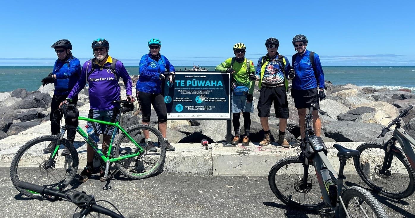 Coastal mountain bike group on seaside trail, ocean backdrop
