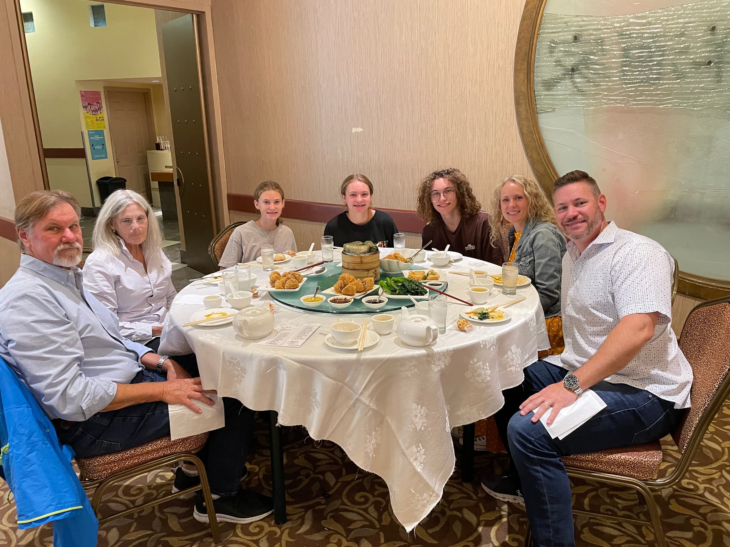 Family sharing dimly lit Cantonese banquet at round table