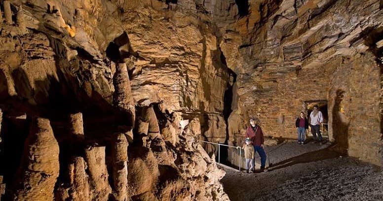 Guided visitors walking cavern trail through stalagmites at Lincoln Caverns