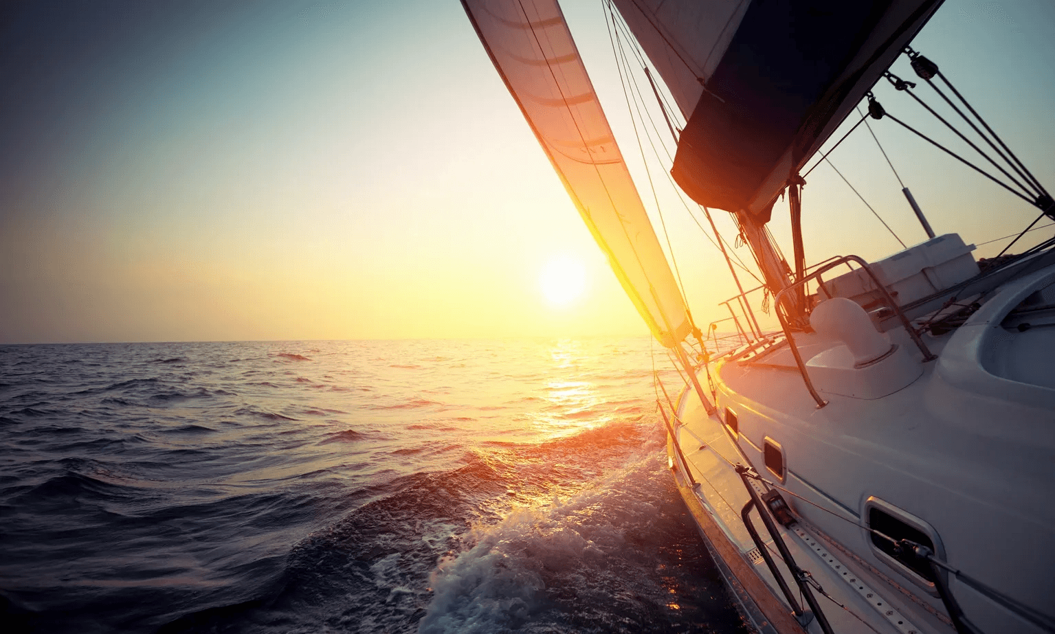 Sailboat racing at sunset on open ocean, adventurous coastal sail