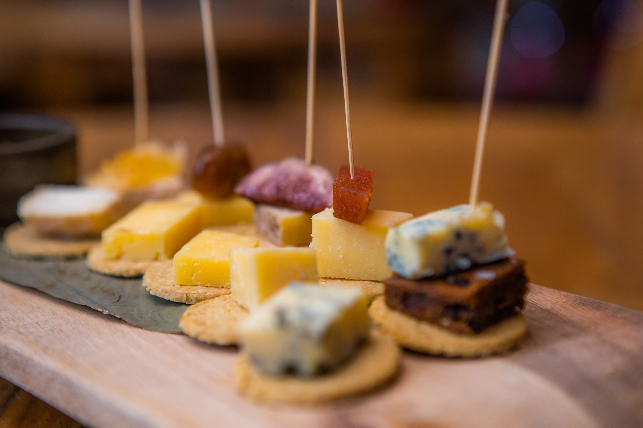 Close-up cheese and charcuterie skewers on wooden board