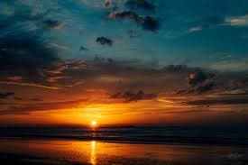 Dramatic sunset over calm ocean horizon at beach