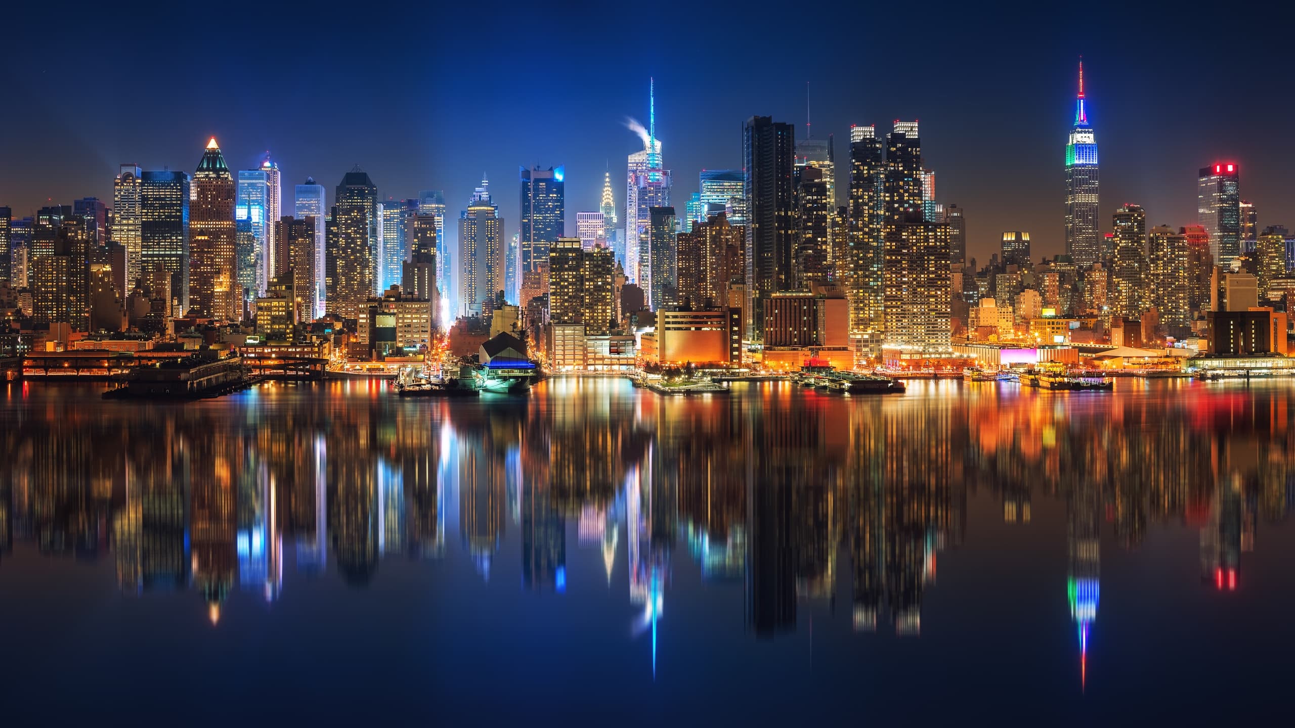 Nighttime Manhattan skyline reflecting on East River in NYC