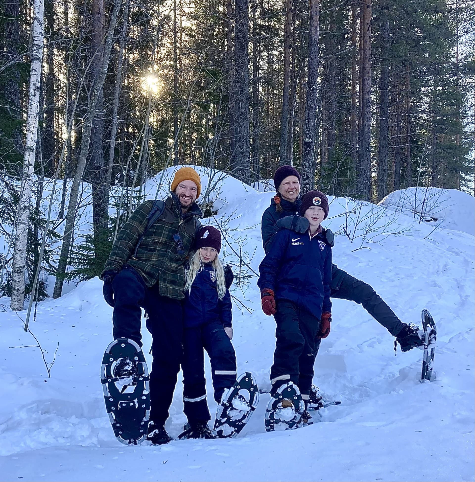 Family snowshoeing on snowy pine trail, guided winter hike