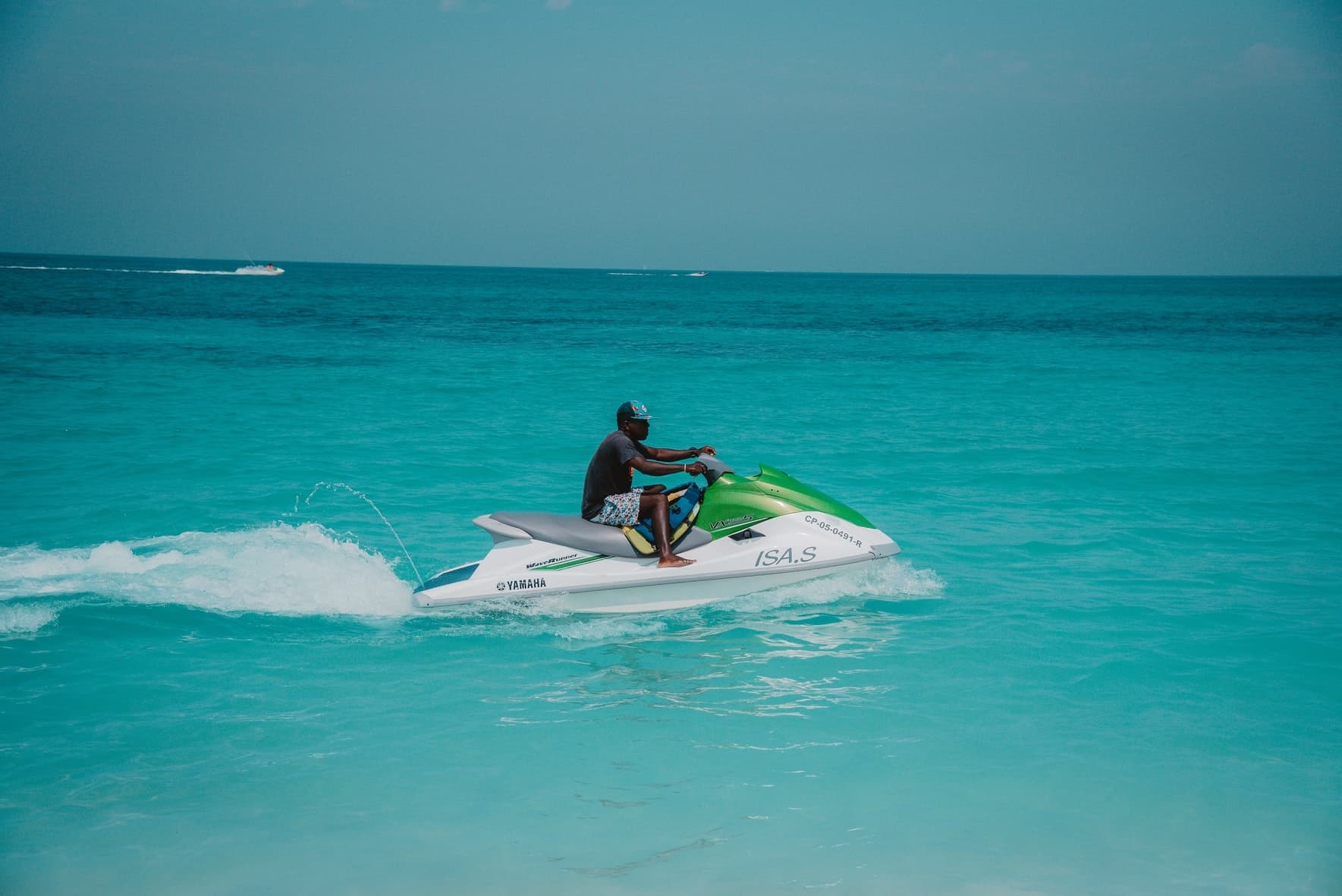 Jetskier riding across turquoise open ocean, high-speed coastal ride