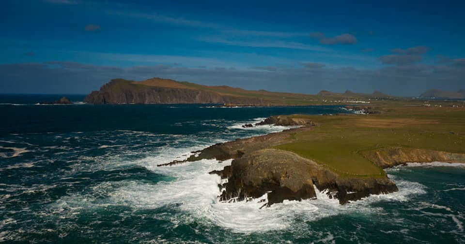 Panoramic ocean headland with waves and grassy cliffs, scenic view