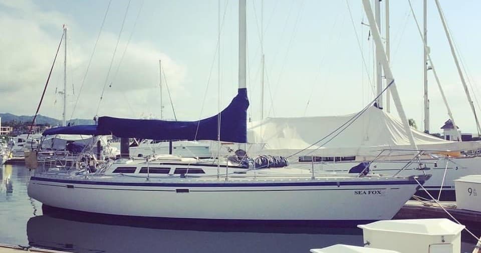 Moored classic sailboat at marina with clear skies