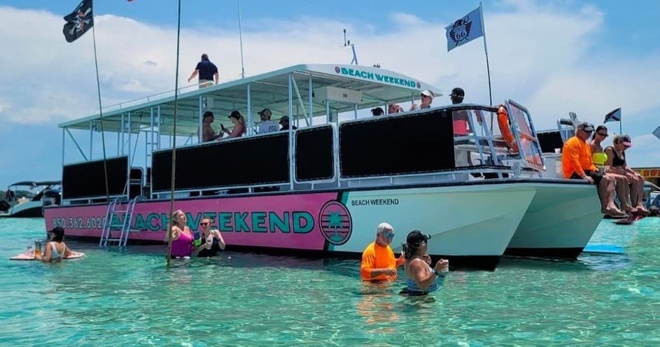 Large party boat with swimmers in clear tropical shallow waters