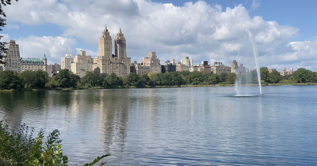 Scenic Central Park reservoir with fountain and skyline reflections