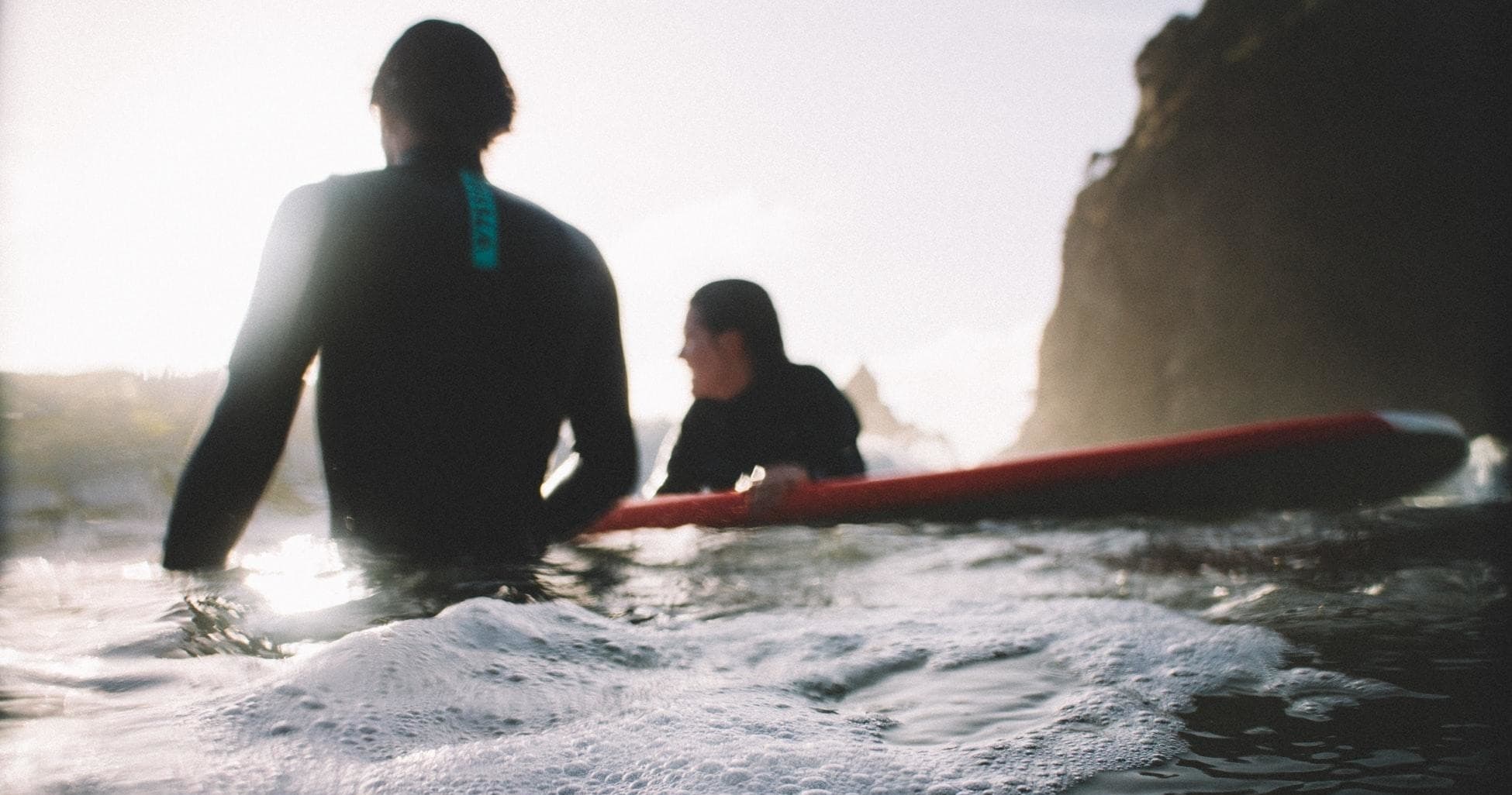 Surf lesson near rocky Mallorca coast at sunrise with instructors