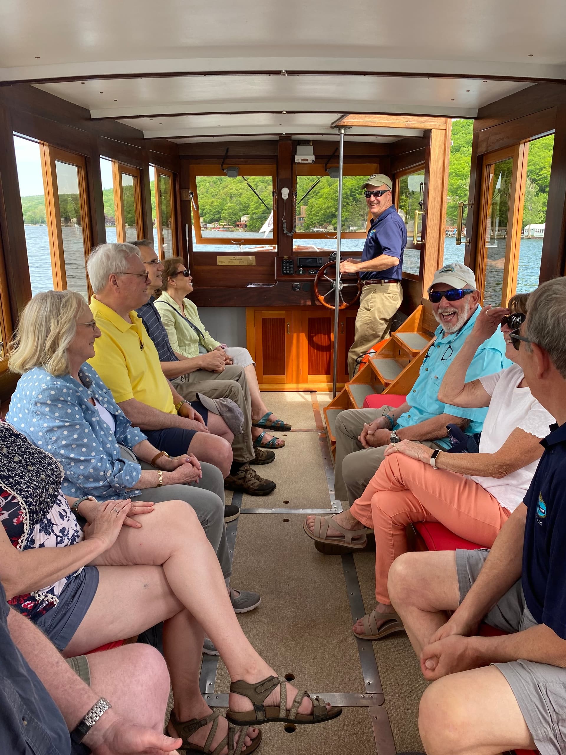 Passengers seated inside wooden tour launch enjoying scenic lake cruise