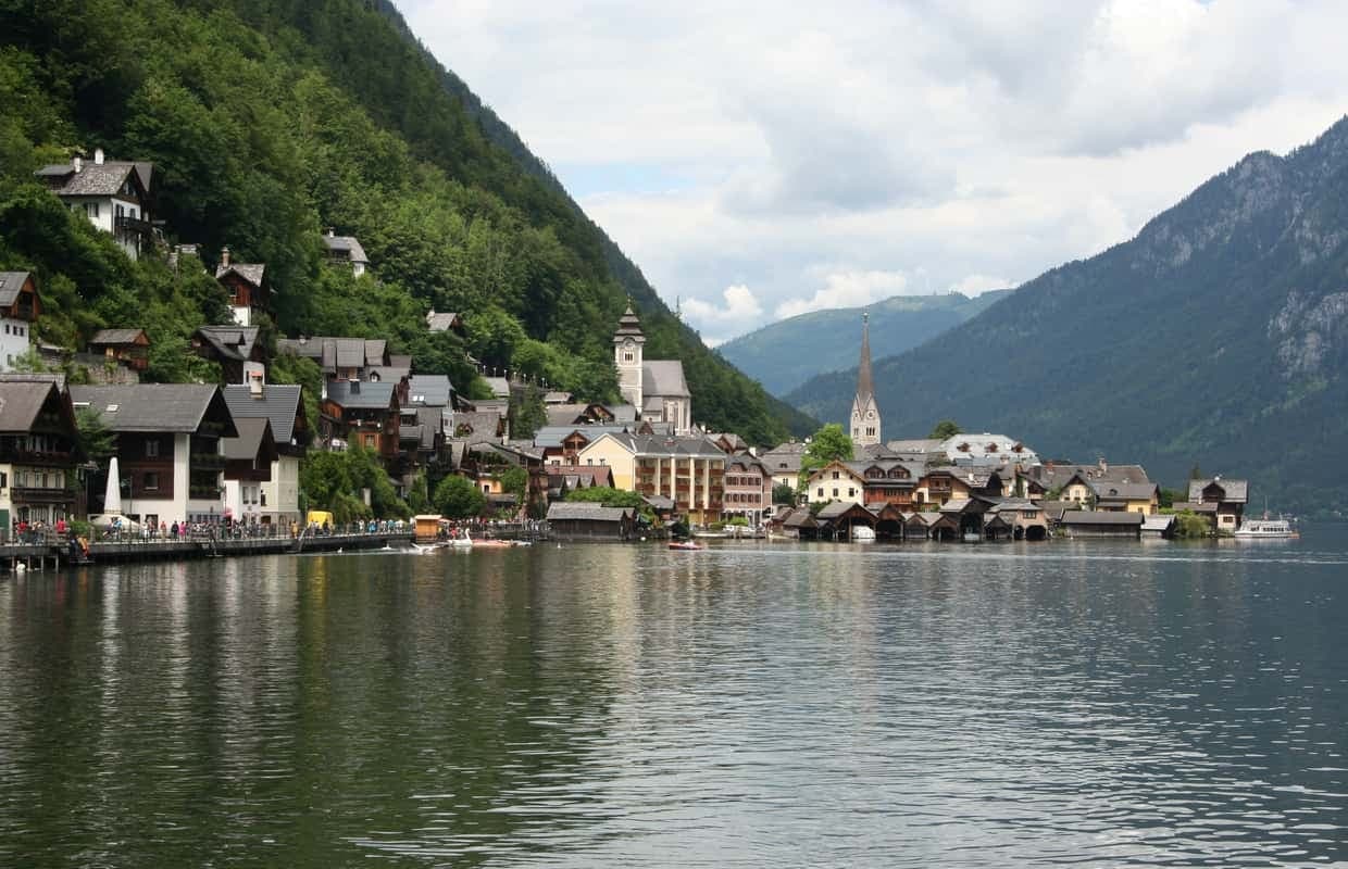 Historic riverside village view, alpine hills, boat sightseeing