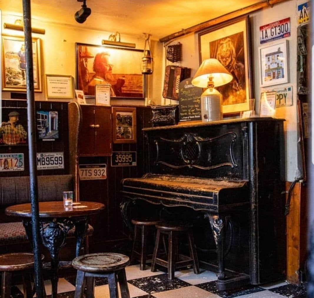 Vintage pub interior with piano and stools, cozy tavern scene
