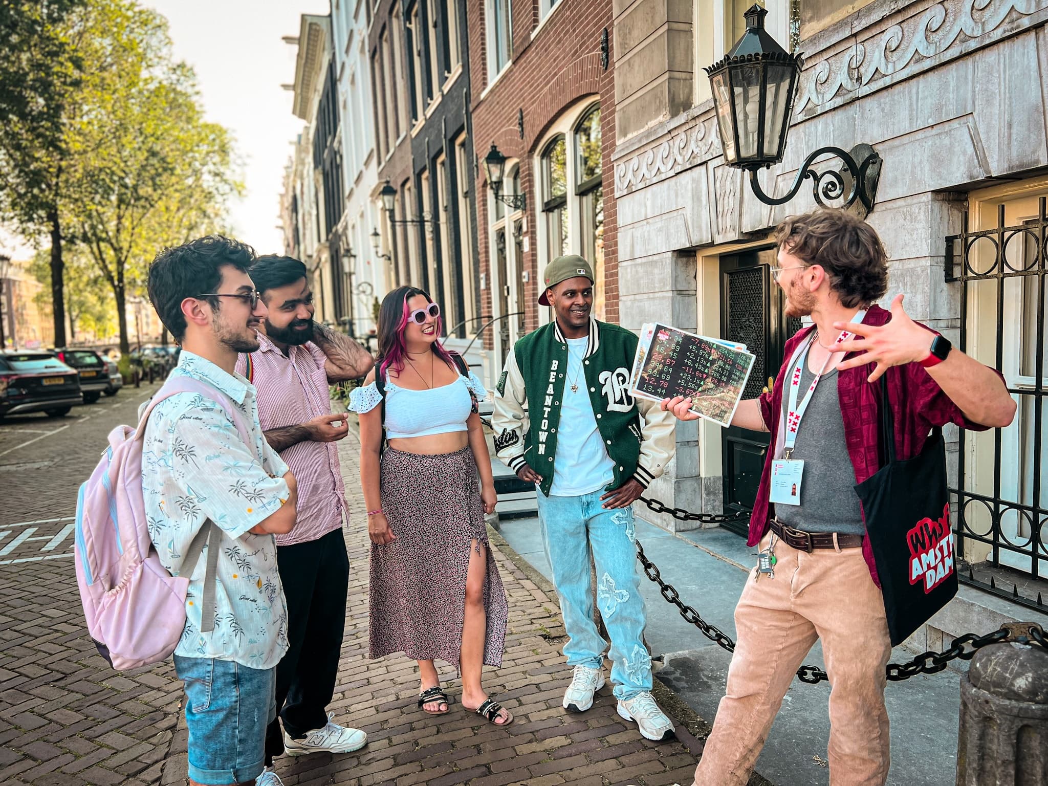 Tour guide showing map to tourists on Amsterdam canal-side street